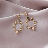 Gold-plated heart flower drop earrings featuring green and white stones, adorned with crystal and cubic zirconia accents.